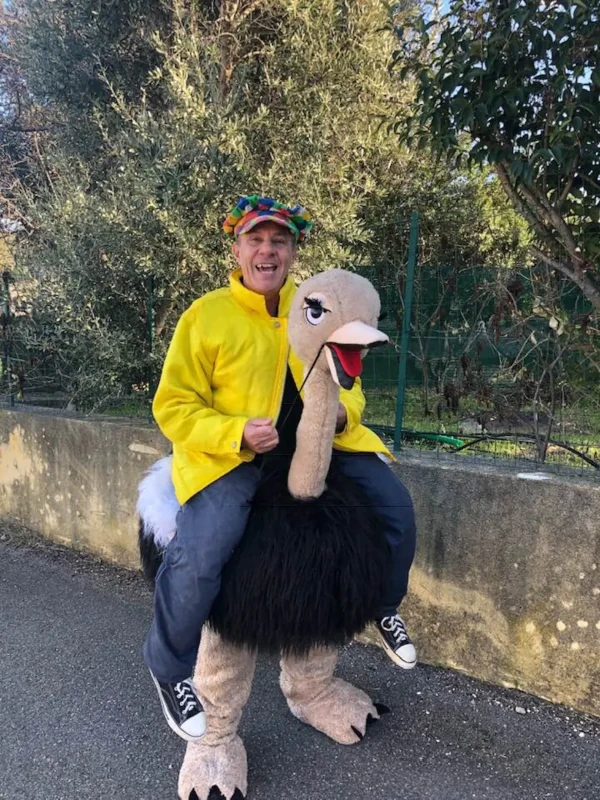 Animateur chevauchant une mascotte d'autruche