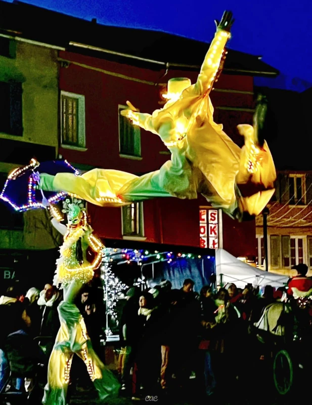 Échassier lumineux jaune en plein saut acrobatique, parade de nuit