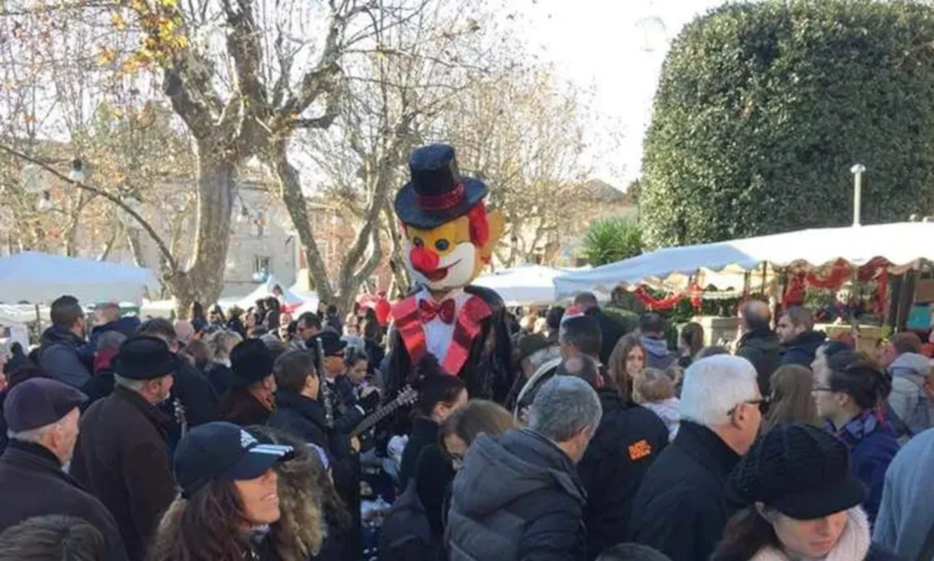 Clown géant au milieu de la foule lors d'un marché de Noël