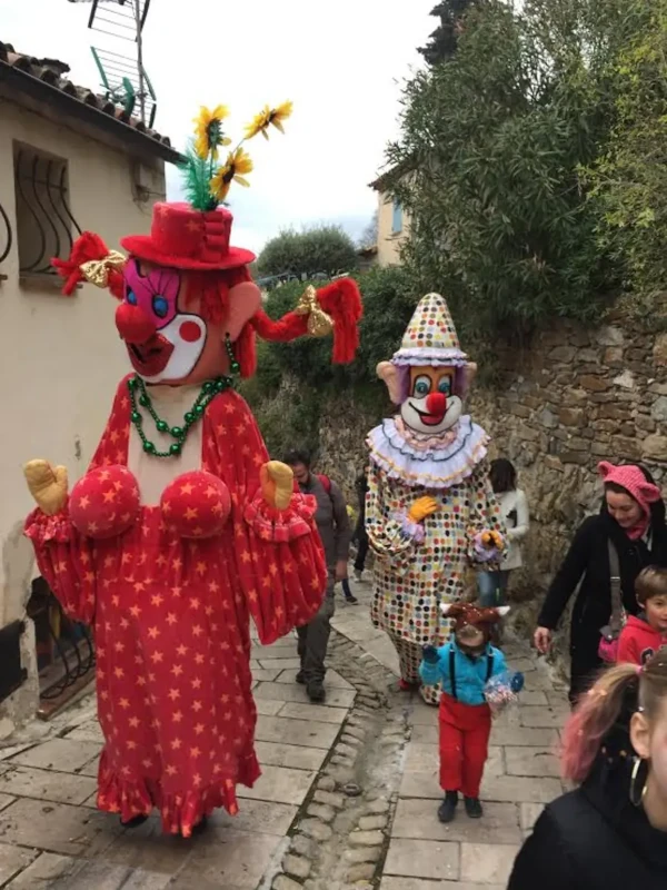 Deux clowns géants dans une ruelle de village