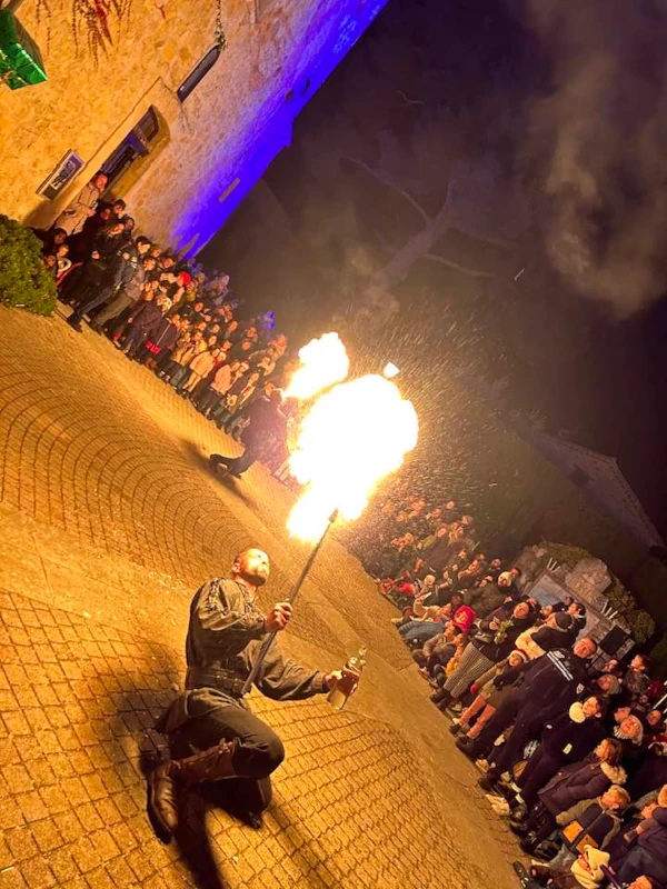 Cracheur de feu devant la foule dans une ruelle