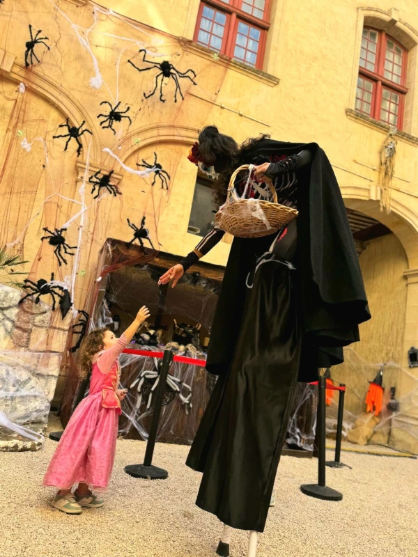 Échassière en costume de faucheuse, décor de toiles d'araignées