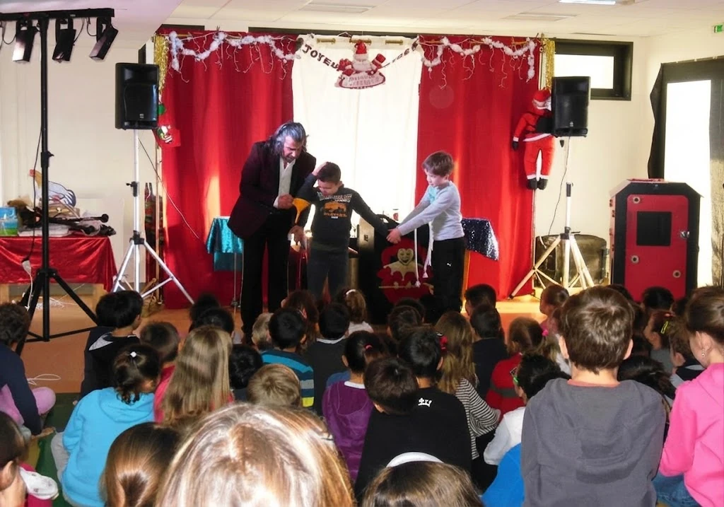 Magicien en spectacle devant un public d'enfants