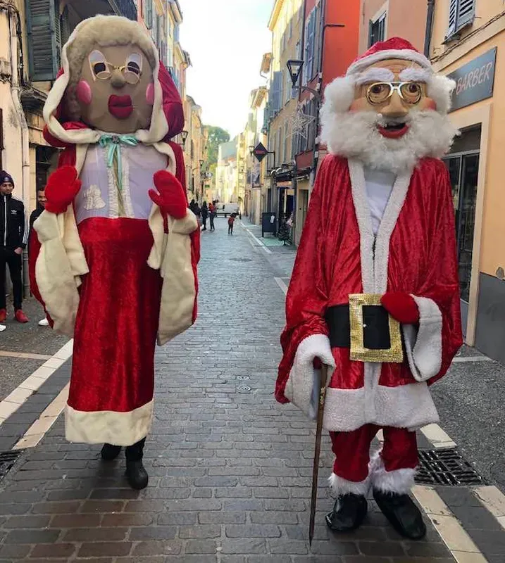 Père Noël et Mère Noël géants dans une ruelle du vieux village
