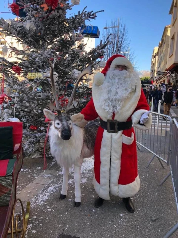 Père Noël avec un renne, décor de sapin enneigé