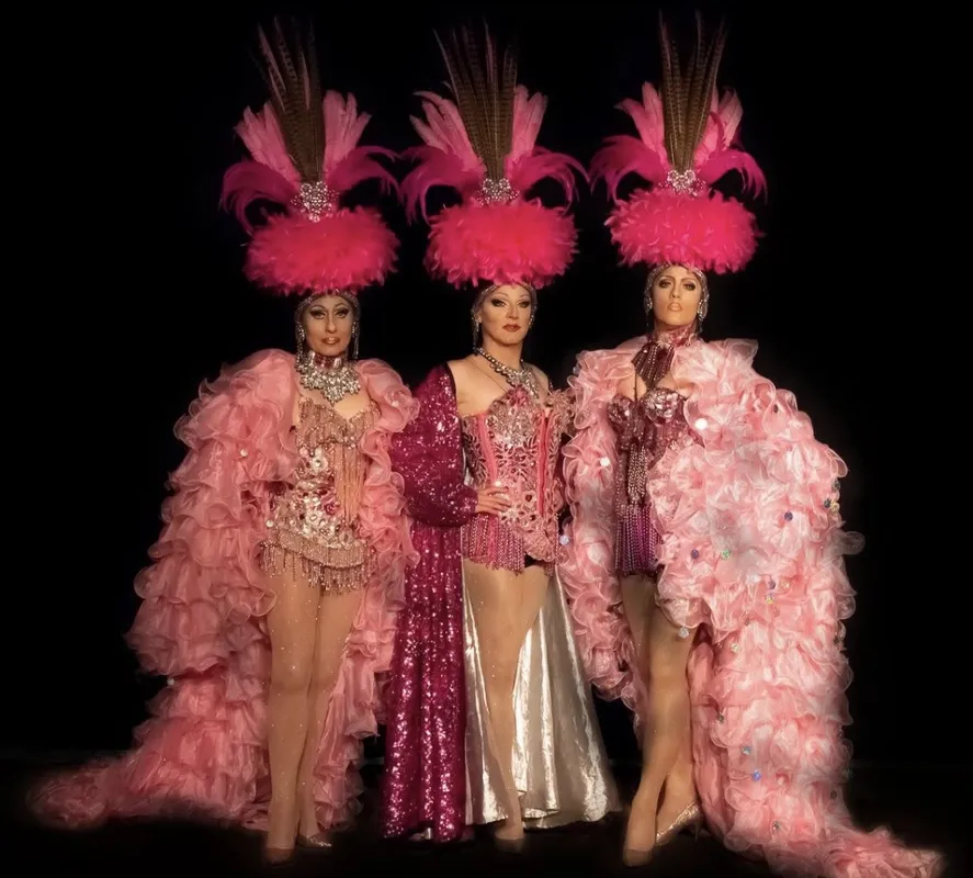 Trio de transformistes en robes roses à volants