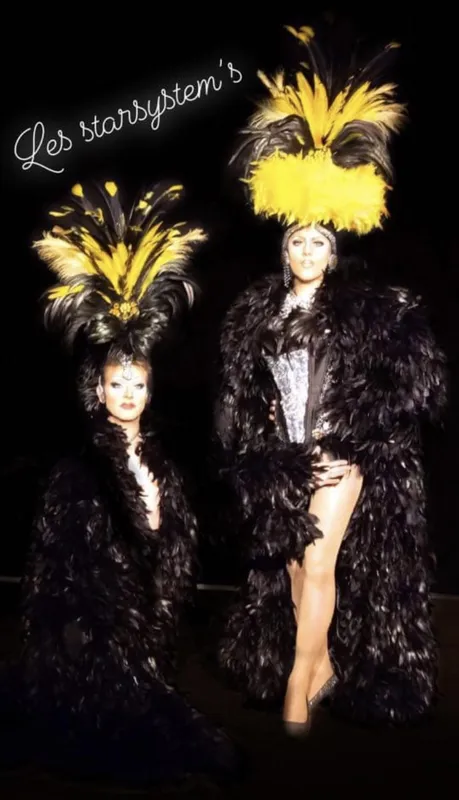 Duo de transformistes en costumes de plumes noires et jaunes