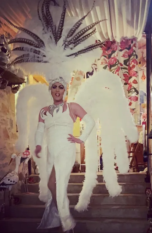 Transformiste en robe blanche à plumes