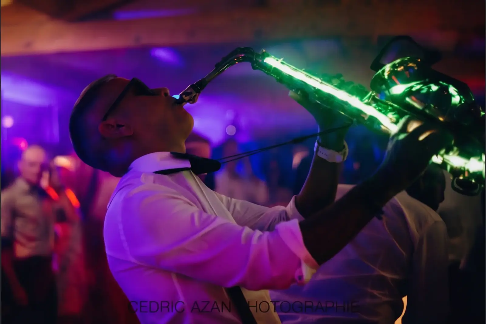 Saxophoniste avec saxophone lumineux LED vert en soirée