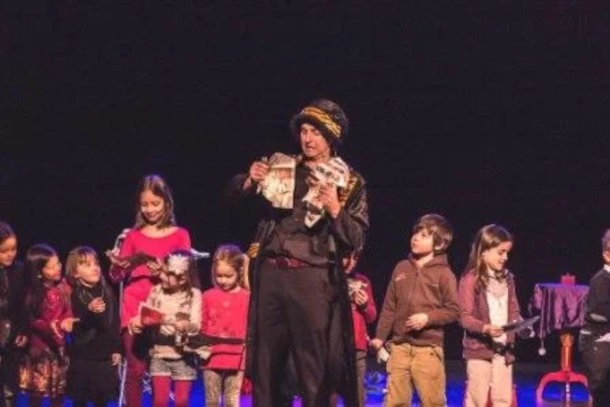Magicien avec un groupe d'enfants sur scène
