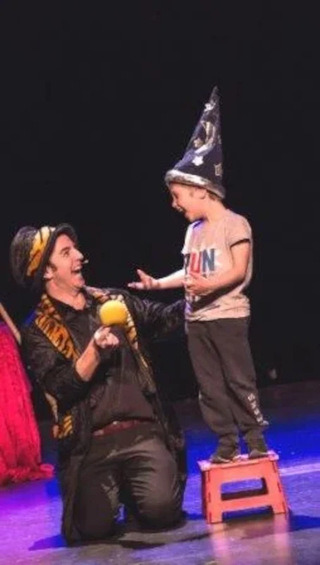 Magicien de Noël avec un enfant sur un tabouret