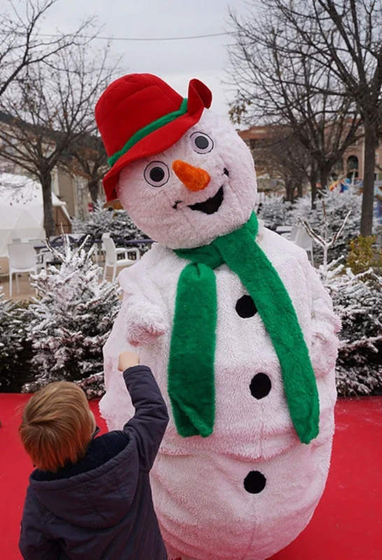 Mascotte bonhomme de neige avec un enfant